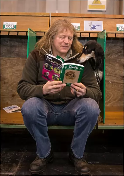 General shot of dog reading Crufts guide with handler