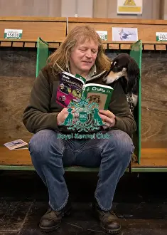 General shot of dog reading Crufts guide with handler